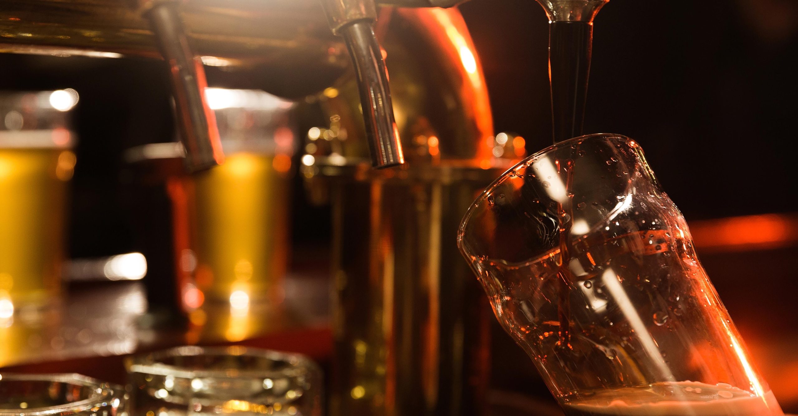 Close up of a bartender pouring beer while standing at the bar counter